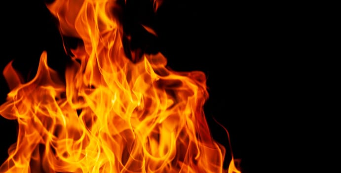 Decorative background with fire flames on black with copy space