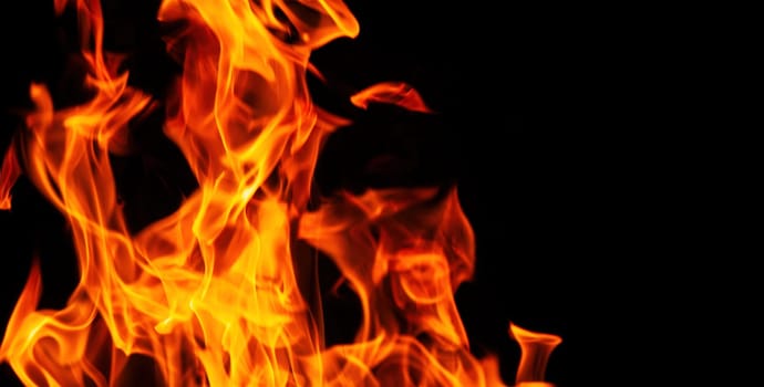 Decorative background with fire flames on black with copy space