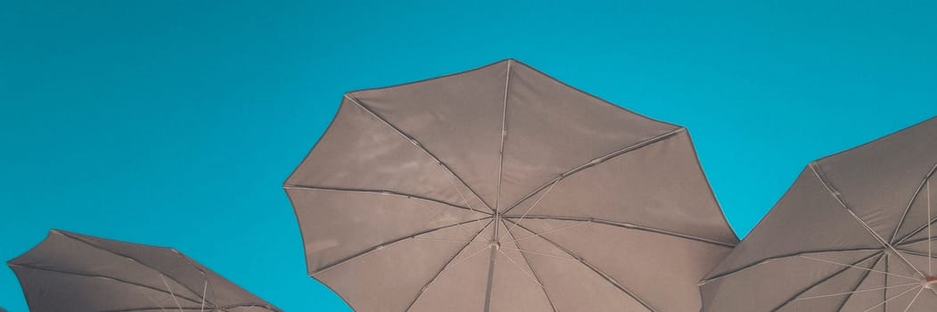 Banner of beach umbrellas against the background of a clear blue sky. vacation and beach holiday concept. soft focus.