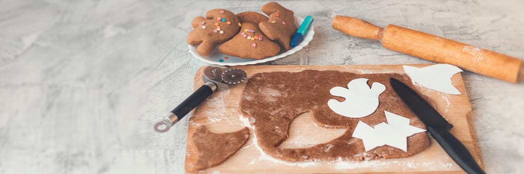 Banner of Halloween ginger cookies. Making homemade gingerbread cookies for Halloween. Halloween cookies on textured. Funny ginger biscuits. Soft focus. Toned