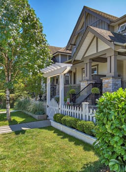 A perfect neighbourhood. The porch of a nice residential house entrance with wooden gate and white birch in front.
