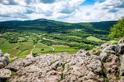 view from the top of the Roche de Solutre with vineyards, and the giant rock to climb on the background, Burgundy, France