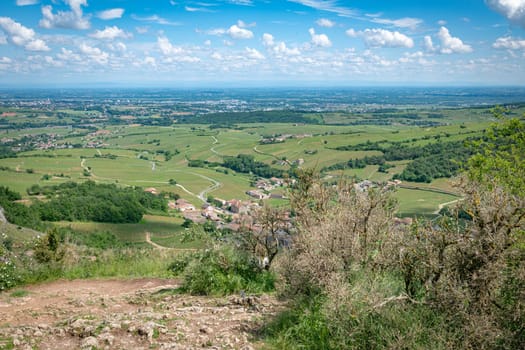 view from the top of the Roche de Solutre with vineyards, and the giant rock to climb on the background, Burgundy, France