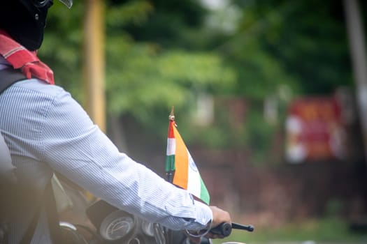 macro shot of man on motorcycle with Indian tricolor flag mounted showing national pride and celebration of independence and republic day