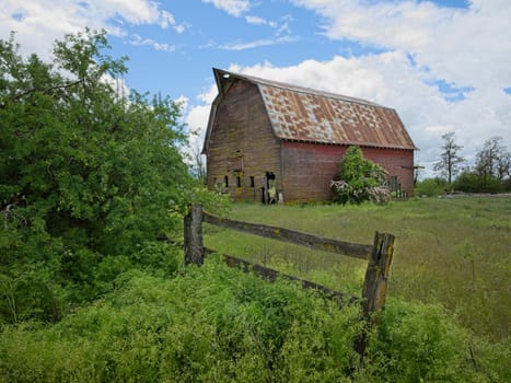 A landscape photo of an old abandoned barn under a dramatic cloudy sky in north Idaho.