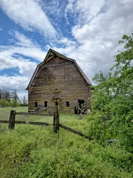 A landscape photo of an old abandoned barn under a dramatic cloudy sky in north Idaho.