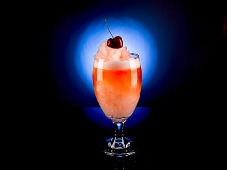 Close up studio photo of a frozen cocktail with a cherry on top.