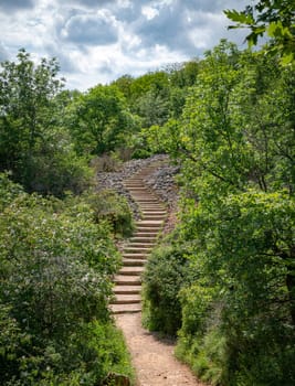 the hiking trail with steep steps up to the top of the Roche de Solutre to the giant rock to climb Burgundy, France