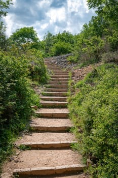 the hiking trail with steep steps up to the top of the Roche de Solutre to the giant rock to climb Burgundy, France