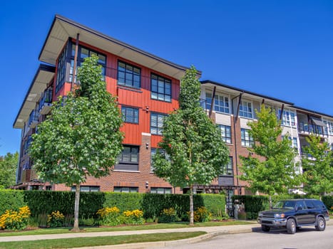 New residential apartment building with a car parked on the roadside.