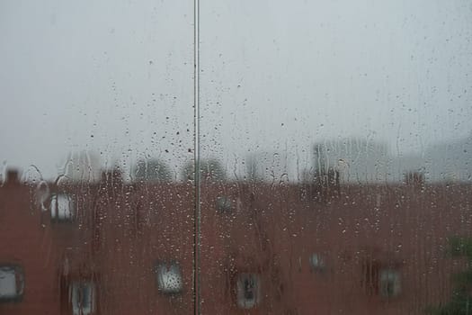 Misted window with flowing down water drops. High quality photo. Summer rain