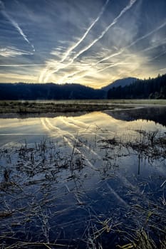 An early morning landscape photo of the sky and clouds reflecting off the calm St. Joe River near St. Maries, Idaho.