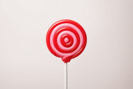 Vibrant spiral lollipop in pink and red, featuring a classic candy swirl pattern.