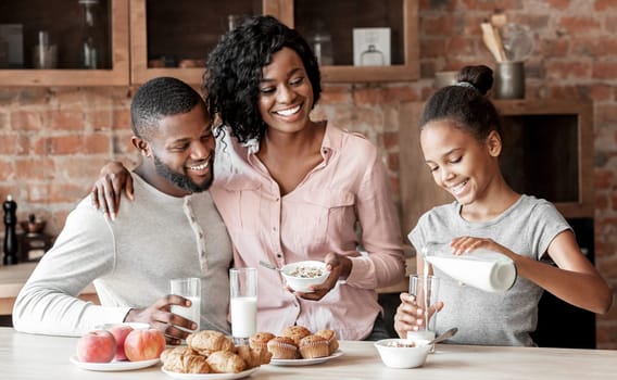 Vitamins and minerals. Beautiful black family having breakfast together, girl pouring milk, copy space