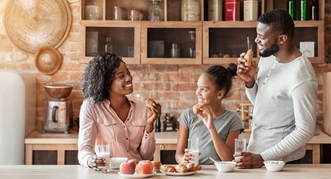 Friendly african american family having conversation during breakfast at kitchen, happy cozy atmosphere, copy space