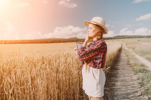 Woman farmer walks through a wheat field at sunset, touching green ears of wheat with his hands. Hand farmer is touching ears of wheat on field in sun, inspecting her harvest. Agricultural business.