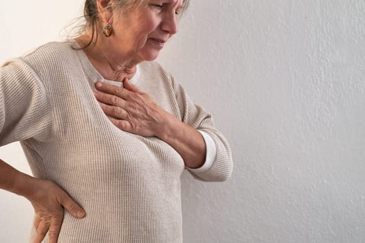Woman having a pain in the heart area. Heart Attack. Painful Chest.