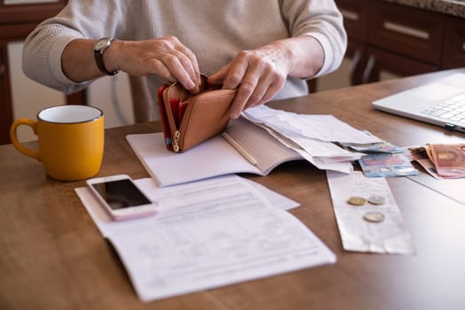 Portrait of an old woman counting money. The concept of old age, poverty, austerity.