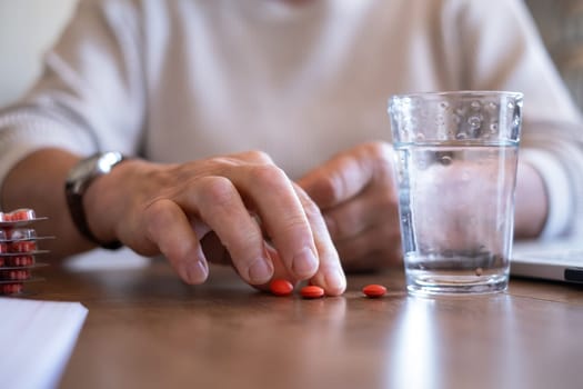 Senior woman takes pill with glass of water in hand. Stressed female drinking sedated antidepressant meds. Woman feels depressed, taking drugs.