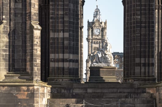 Edinburgh, Scotland - Jan 16, 2024 - Statue of Sir Walter Scott (Scottish author) and Balmoral Hotel Clock Tower at The Scott Monument is a Victorian Gothic monument. It is the largest monument to a writer in Princes Street Gardens at the city of Edinburgh. Copy space, Selective focus.