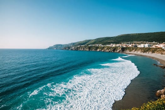 Step into an idyllic coastal haven with this captivating image of a sandy beach bordered by green cliffs. The charming white village perched on the hillside provides a picturesque backdrop, creating a perfect setting for a peaceful getaway by the sea.
