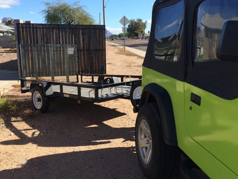 Green SUV Pulling Trailer, Just Hitched it up in my Driveway . High quality photo