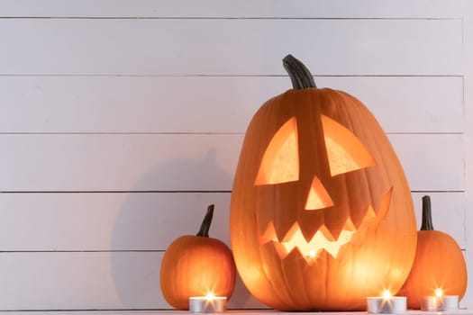 Halloween pumpkins with cut faces and candles light holiday card