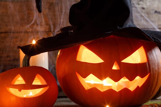 Still life of Halloween pumpkin lanterns pumpkins and hats decoration in candle light