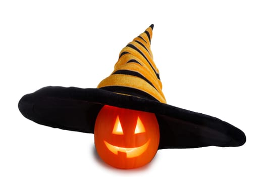 Cute small Jack o lantern Halloween pumpkin in oversized hat on wooden background