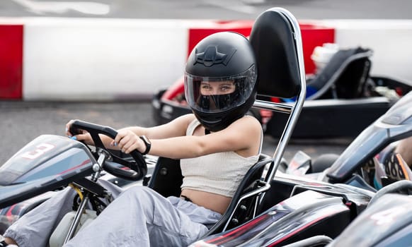 Portrait Of Young Girl In Protective Helmet In Racing Go-Kart On A Track