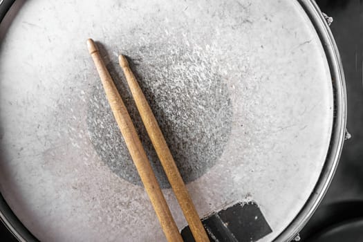 Drumsticks lying on drum in recording studio. Wooden musical sticks for percussion instruments