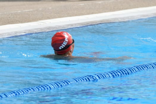 A swimmer in a red cap swims in the Dieppe pool in France
