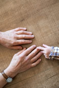 Old female hand holding young baby hand. High quality photo