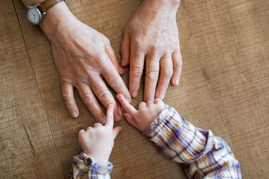 Old female hand holding young baby hand. High quality photo