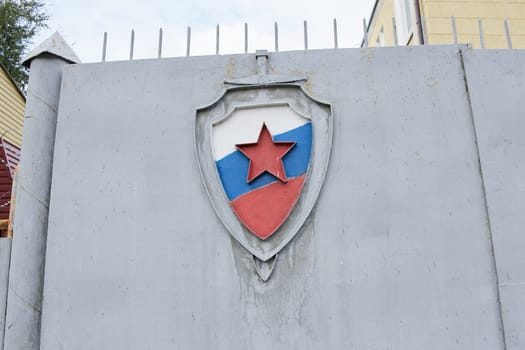 grey fence of the Russian military department with the coat of arms