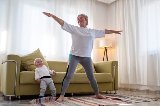 Senior caucasian woman doing yoga at home using chair as a props.
