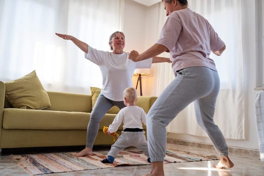 Senior woman exercising at home together with daughter. Active mature woman doing stretching exercise in living room at home.