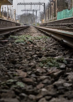 London, UK - Dec 25, 2023 - Railway iron rails from the low perspective. Railroad tracks with limited depth of focus, The Railway system with Metal frames of Train platform, Railroad track rails, Train tracks, Railway station, Space for text, Selective focus.