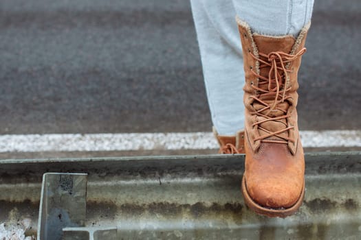 Leather boot on the side of the road stop before a long journey. A long walk in search of adventure.