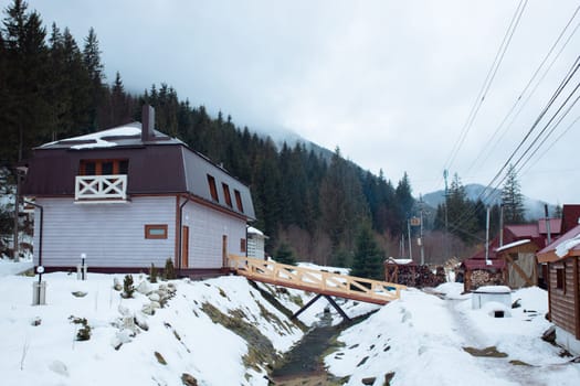 Wooden one-storey house in the mountains. Countryside forest and mountains.