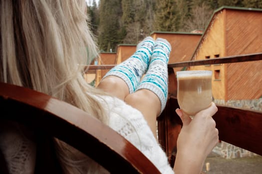 A young beautiful woman in warm handmade knitted clothes at home. . spring, winter season. Gaiters. Knee socks. Leggings.
