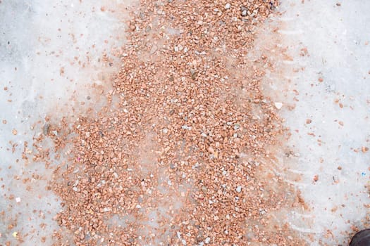 Pedestrian road sprinkled with salt and sand mixtures. De-icing chemicals on pavement. Prevent slipping on road with sand and reagents - technical salt. Icy road and danger of injury on slippery road.