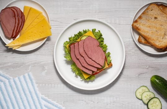 Big sandwich with tomato, cucumber, ham, cheese and salad.