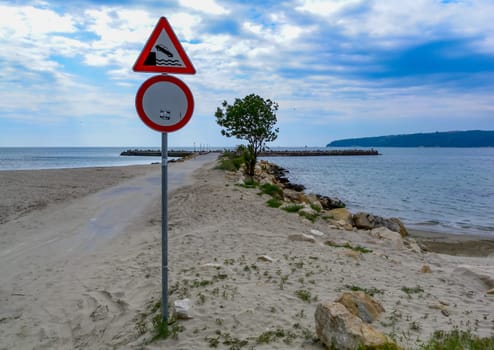 BULGARIA, VARNA - JUNE 06, 2013: 
warning sign at the entrance to the dam on the seashore in Varna, Bulgaria