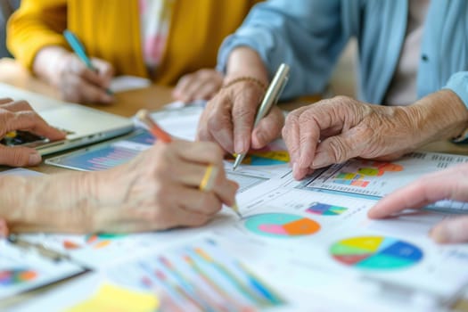A group of elderly people collaborates at a table, analyzing various charts and graphs, discussing insights and sharing ideas.