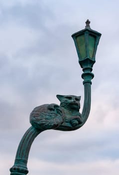 UKRAINE, ODESSA - DECEMBER 25, 2018: the cat sits on a crooked street lamp, a sculptural composition made of metal, Odessa