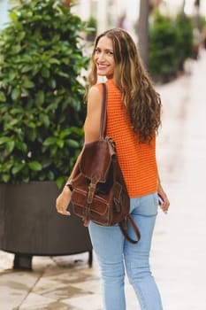 Vertical portrait of a beauty latin woman turning to smile walking outdoors