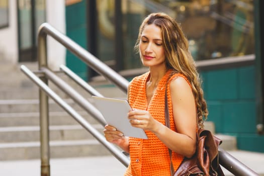 Latin beauty blonde woman using tablet standing in the city