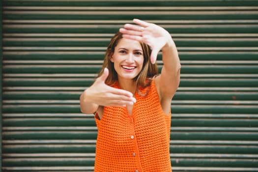 Portrait of a latin beauty woman gesturing a frame with hands outdoors