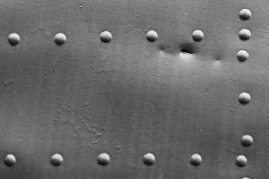 Metal casing with rivets for an aircraft...Old damaged metal wall with rivets close-up.